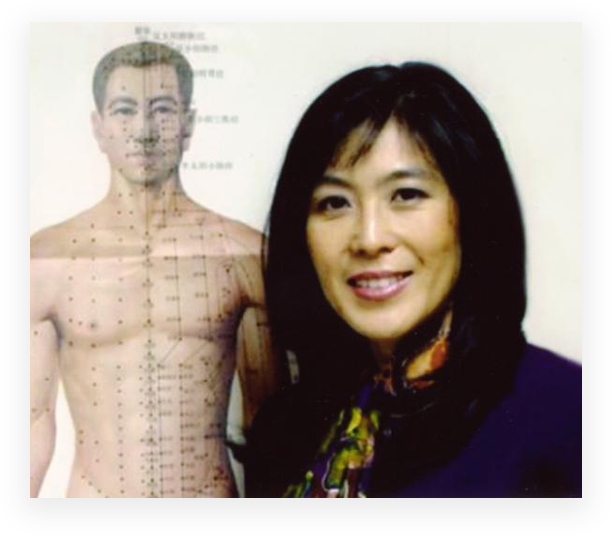 A woman standing next to an acupuncture chart.