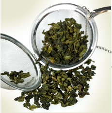 A tea strainer and some green leaves